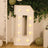 Large illuminated letter 'D' in a festive setting with greenery and balloons.