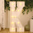 Illuminated marquee letter "K" with lights, styled in a festive setting.