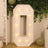 Light-up marquee number zero in a decorative setting with greenery and balloons.