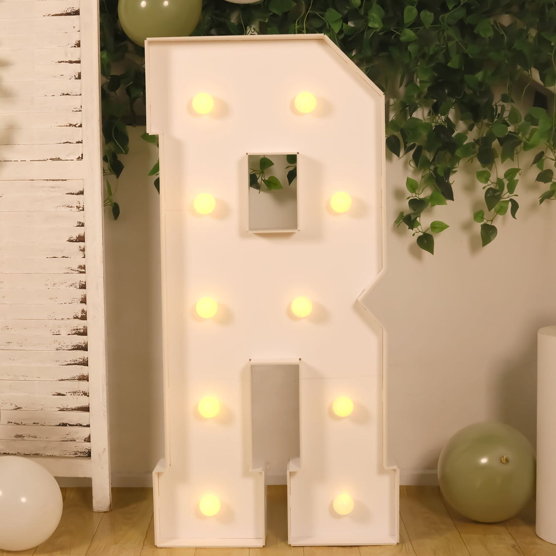 Light-up letter R decor with bulbs, ideal for events and celebrations.