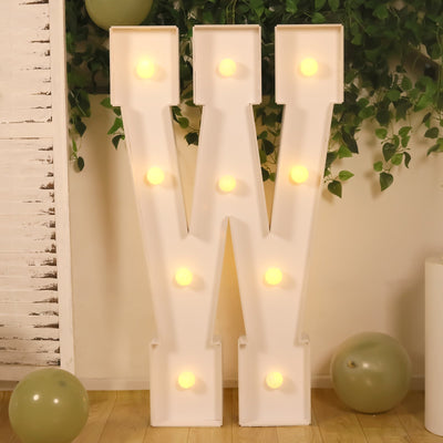 White marquee letter W with warm lights at party backdrop