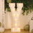 Illuminated decorative letter Y with lights, surrounded by greenery and balloons.