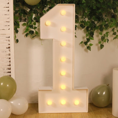 Large illuminated number 1 marquee sign with balloons and greenery backdrop