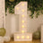 Large illuminated number 1 marquee sign with balloons and greenery backdrop