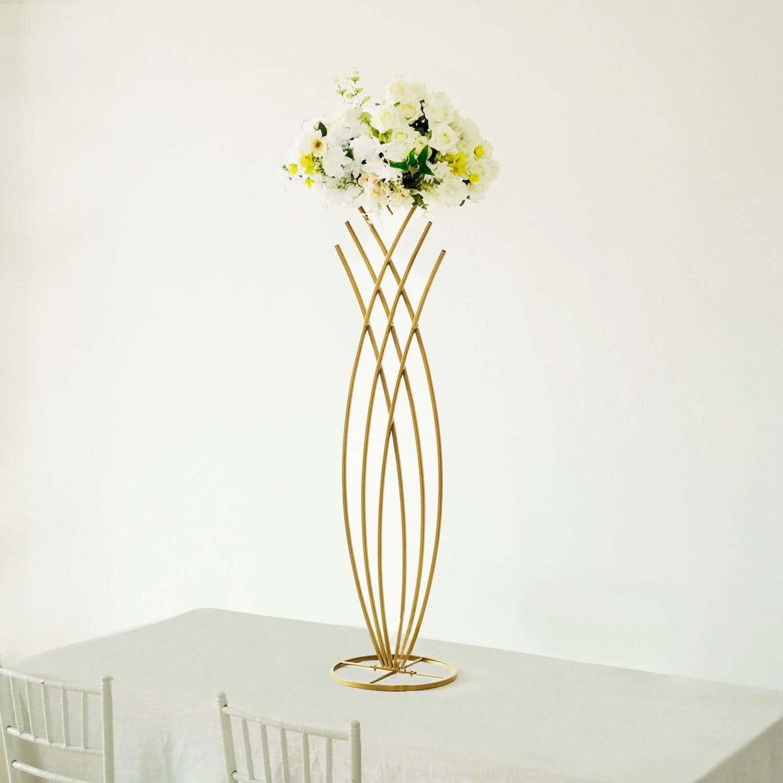 Gold flower vase with white flowers on a minimalist table