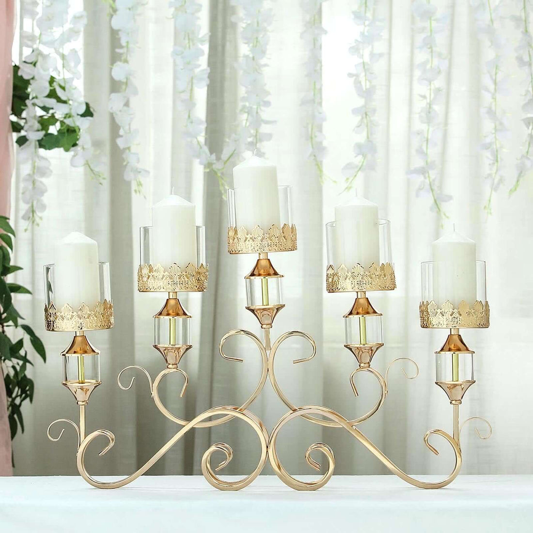 Elegant gold candle holder with glass vases for pillar candles.