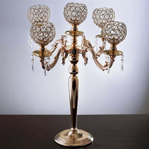 Elegant gold candelabra with crystal globes and decorative details.