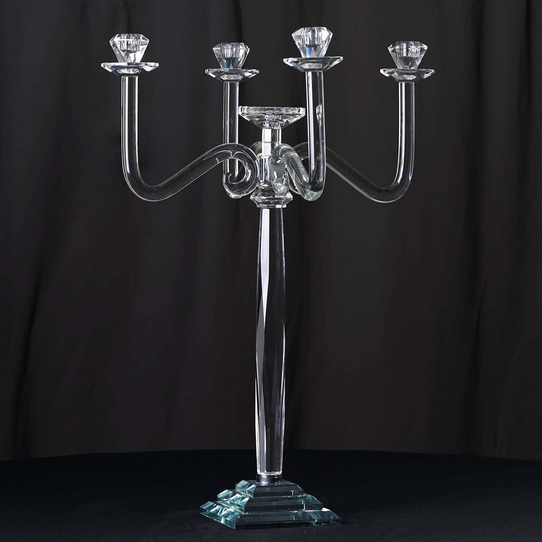 Elegant crystal candelabra with four arms and diamond-shaped holders.