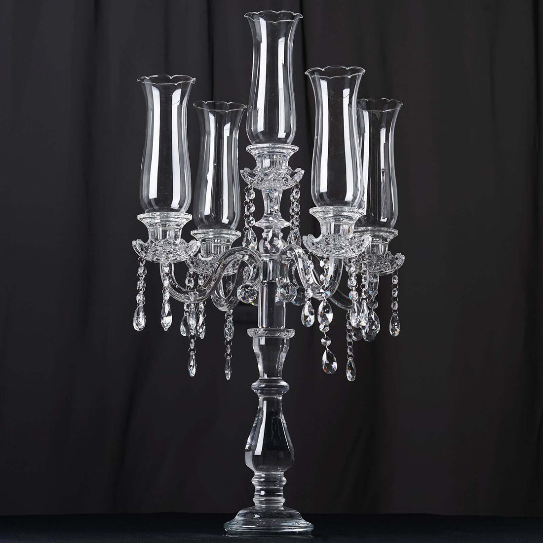 Elegant crystal candelabra with five holders and hanging beads.