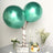 Green metallic balloons with a cake and flowers on a table setting.