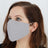 Gray reusable face mask worn by a model.