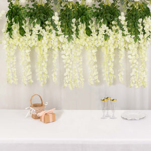 Decorative white flowers hanging above a table with gifts and glassware.