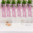 Decorative pink flower garlands with a gift box and champagne glasses on a table.