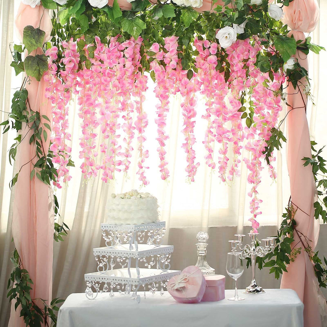 Pink floral hanging decor with white roses for wedding or event backdrop.