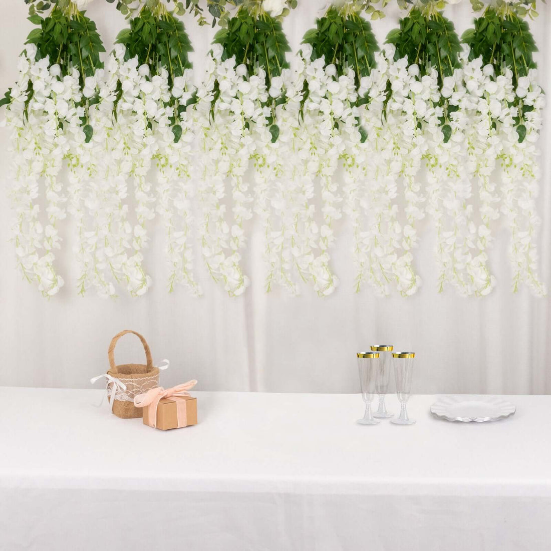 Elegant white floral backdrop with decorative items on a table.