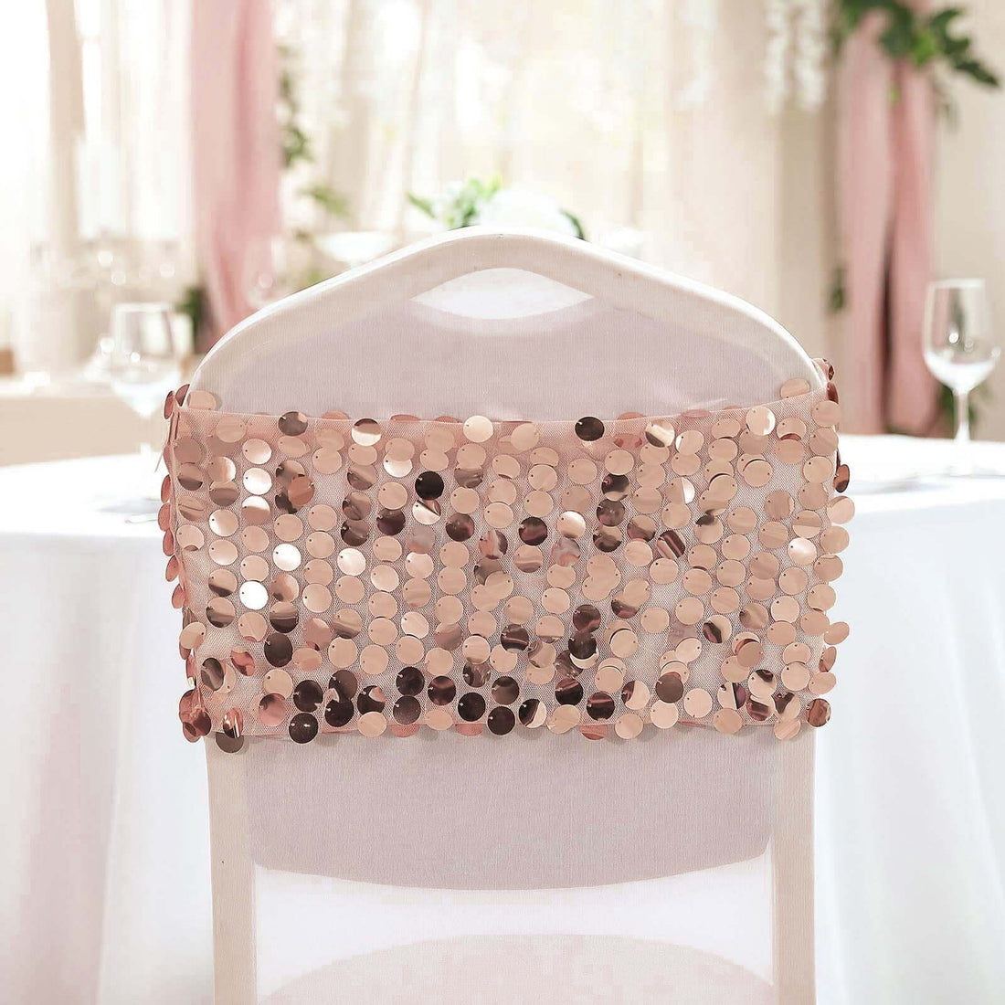 Rose gold sequin chair cover draped elegantly over a white chair.