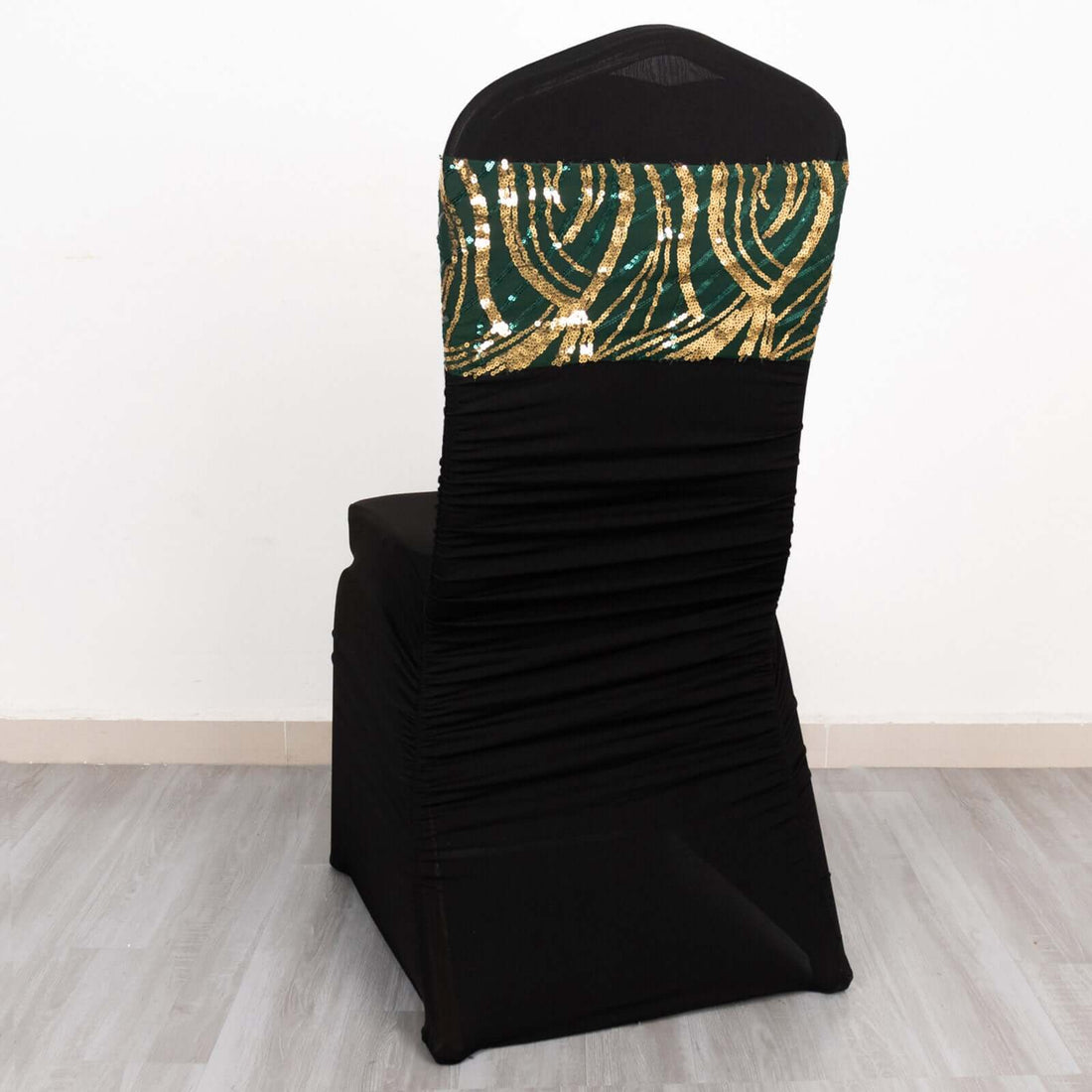 Black chair cover with green and gold sequined design on the back.