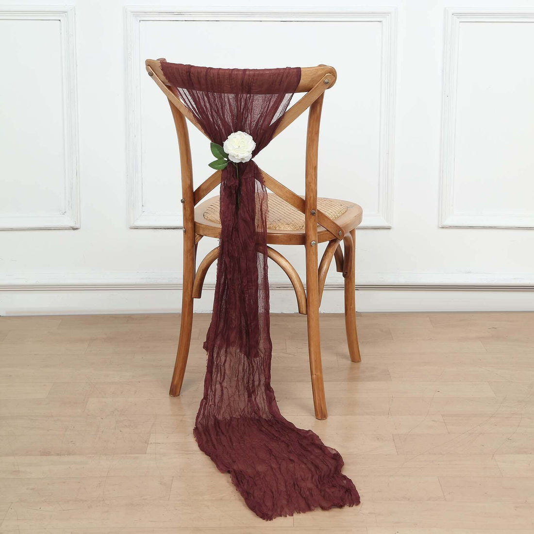 Burgundy chair sash with flower decoration on a wooden chair
