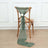 Green textured scarf draped on a wooden chair with a flower accent.