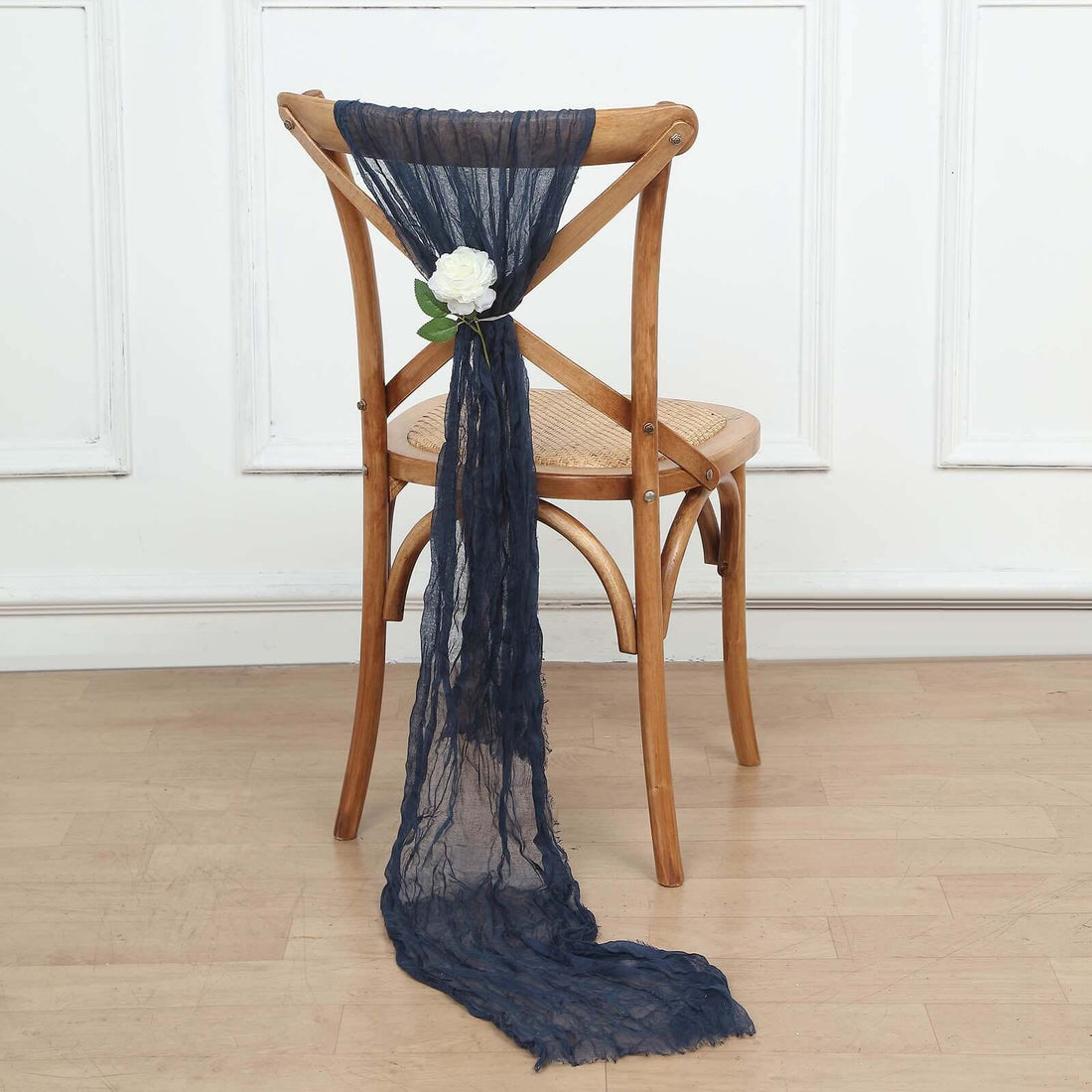 Navy blue chair sash with flower decoration on a wooden chair