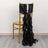 Black chair sash with ruffled design draping over a gold chair.
