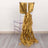 Gold satin chair sash with cascading ruffles on a clear chair.