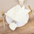 Elegant white napkin with silver ring on a plate, styled for dining.