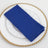 Blue cloth napkin neatly folded on a decorative white plate.