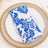 Blue floral patterned napkin on a decorative plate.
