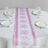 Pink floral table runner on a round dining table with plates and glasses.
