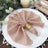 Elegant blush napkin elegantly arranged on a white plate for dining decor.