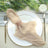 Elegant beige napkin tied with rose gold rings on a stylish dining plate.