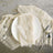 Elegant table setting with cream linen, white plate, and silver utensils.