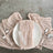 Elegant pink linen napkin on a white plate with silver cutlery.
