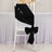 Black satin chair sash tied in a bow on a white chair.
