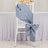 Silk chair sash in soft blue tied in a bow on a white chair