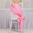 Pink satin chair sash tied in a bow on a white chair.