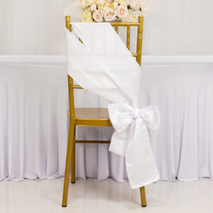 White satin chair sash tied in a bow on a gold chair.