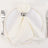 Elegant white napkin with silver ring on a white plate.