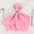 Pink satin napkin tied elegantly with a silver napkin ring on a white plate.