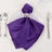 Purple satin napkin elegantly folded on a plate with a silver napkin ring.