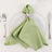 Green napkin elegantly tied with a silver ring on a white plate with cutlery.