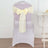 Yellow chair sash bow tied on a transparent chair in a minimalist setting.
