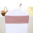 Pink chair sash on a white chair in a decorated event setting.