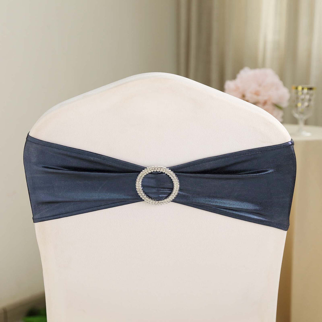Navy blue chair sash with rhinestone buckle on a chair back.