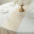 Gold leaf table runner on a white table with elegant decor and table settings.
