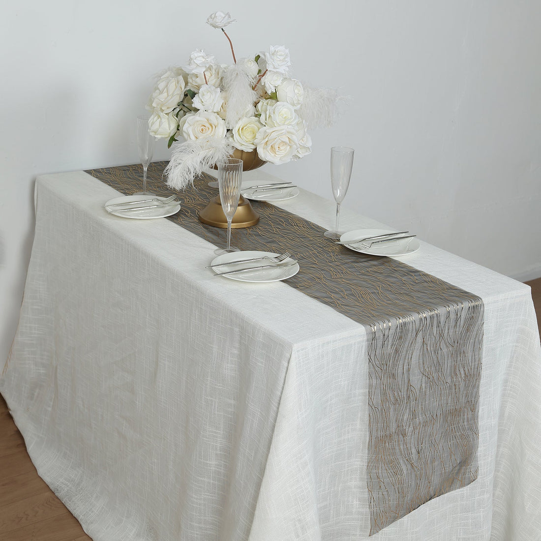 Elegant table setting with floral centerpiece and decorative table runner.