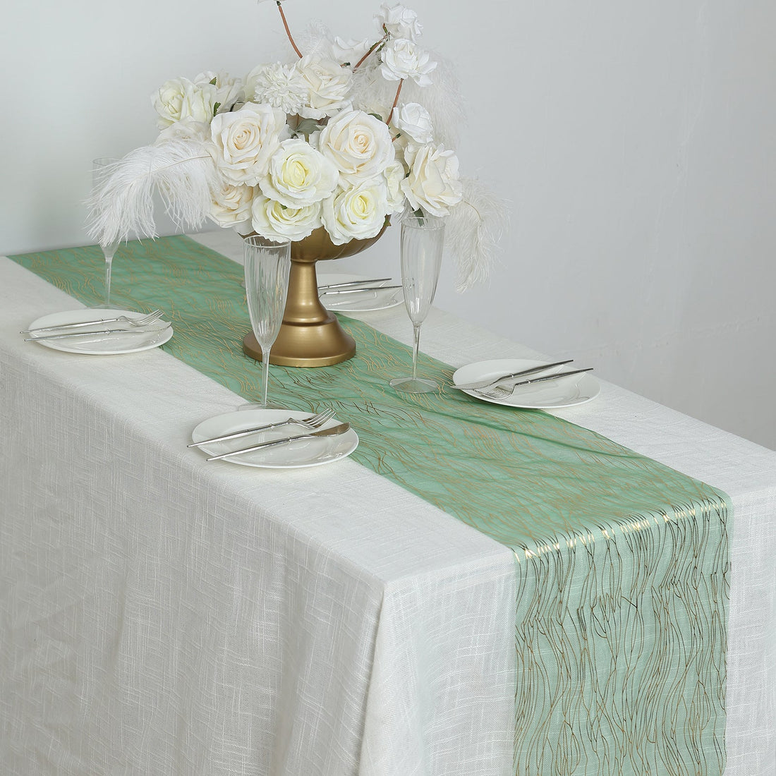 Elegant mint green table runner with gold accents, styled with floral centerpiece.