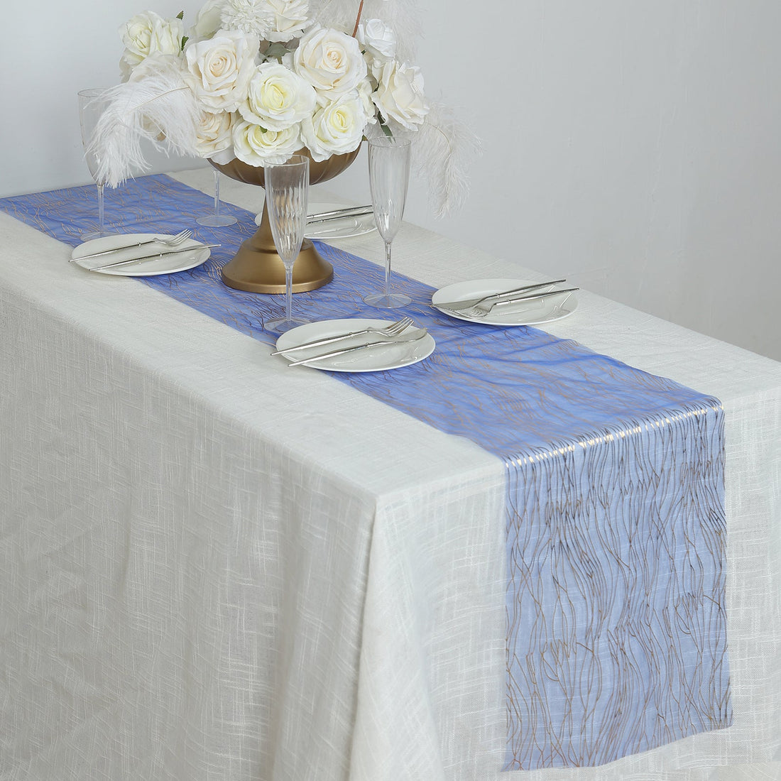 Elegant blue table runner on a dining table with floral centerpiece and tableware.