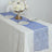Elegant blue table runner on a dining table with floral centerpiece and tableware.